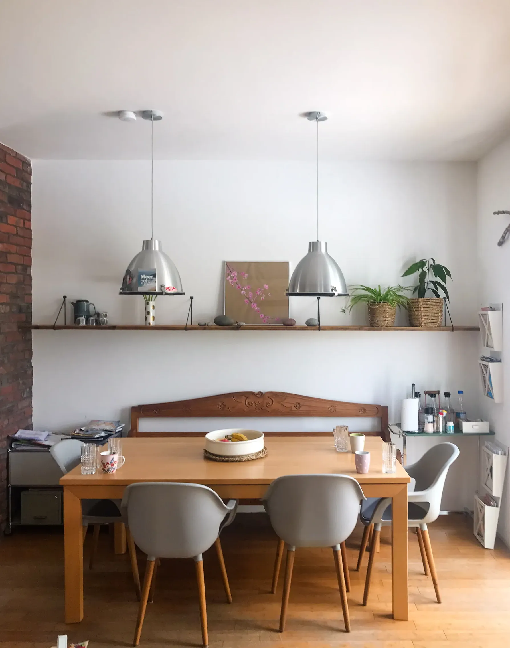 Esszimmer mit heller Holzdecke, modernem Esstisch, grauen Stühlen und zwei Hängelampen – Trockenbau Plus Projekt in Coesfeld mit gemauerter Ziegelwand und stilvoller Regalgestaltung.